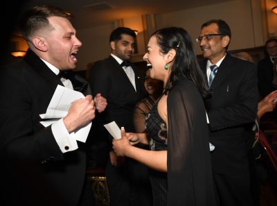 A man and woman scream in excitement clutching a letter. 